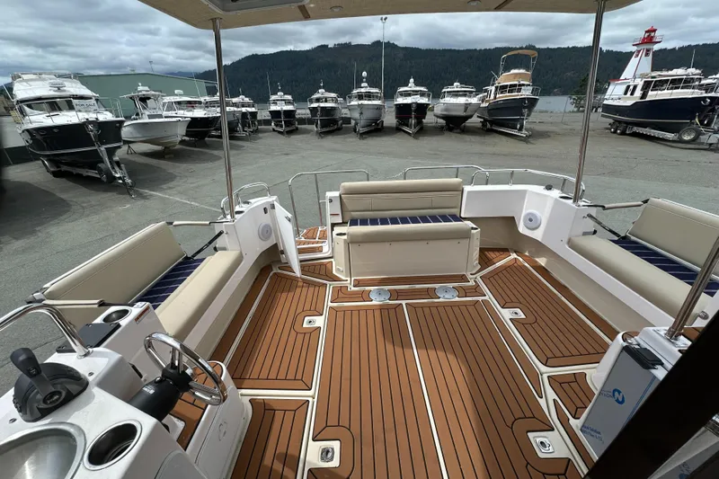  Yacht Photos Pics 2025 Ranger Tugs R-31 CB boat interior with teak flooring and seating, docked among other boats.