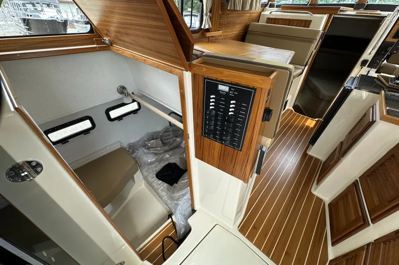  Yacht Photos Pics Interior of 2025 Ranger Tugs R-31 CB, featuring wood paneling and control panel.