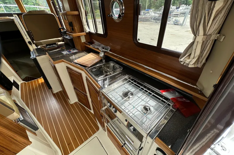  Yacht Photos Pics Interior of 2025 Ranger Tugs R-31 CB, featuring a compact kitchen with stove and sink.