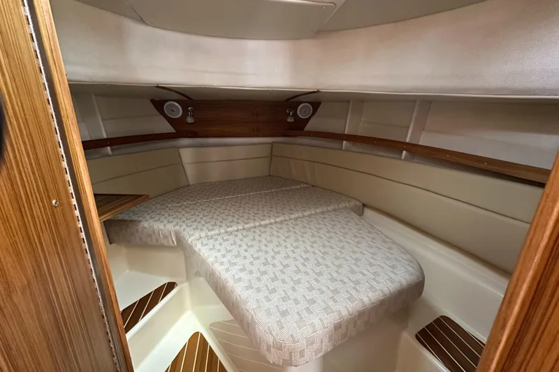  Yacht Photos Pics 2025 Ranger Tugs R-31 CB cabin interior with cozy bed and wooden accents.