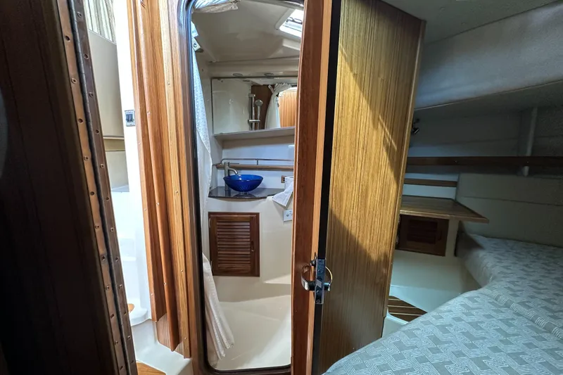  Yacht Photos Pics Interior of 2025 Ranger Tugs R-31 CB, featuring a compact bathroom and cozy sleeping area.