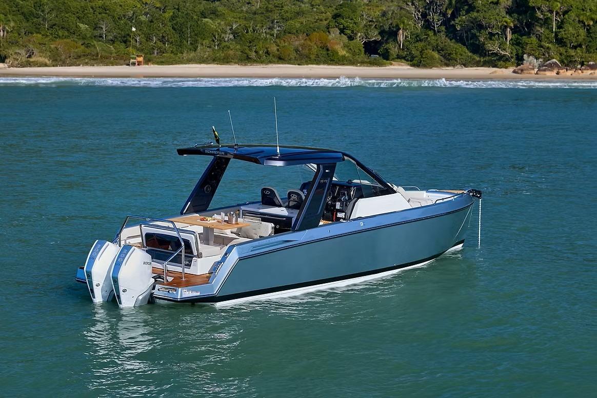 Schaefer V34 2027 boat cruising on clear blue water near a lush green shoreline.