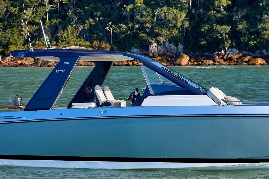 2027 Schaefer V34 yacht cruising on serene waters with lush forest backdrop.