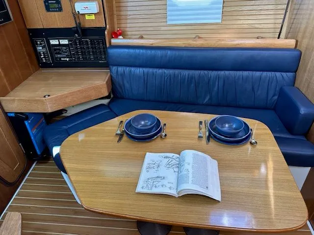 Junebug Yacht Photos Pics Interior of a 2008 Catalina 350 MkII yacht with dining table and blue seating.