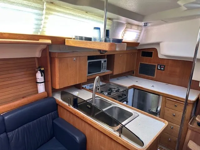 Junebug Yacht Photos Pics Interior of 2008 Catalina 350 MkII with kitchen and seating area.