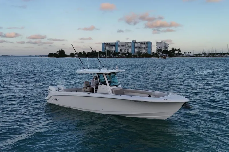  Yacht Photos Pics 2017 Boston Whaler 330 Outrage boat on calm water with cityscape background.