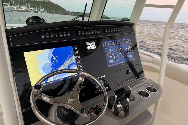  Yacht Photos Pics Boston Whaler 330 Outrage 2017 helm with navigation screens and steering wheel.