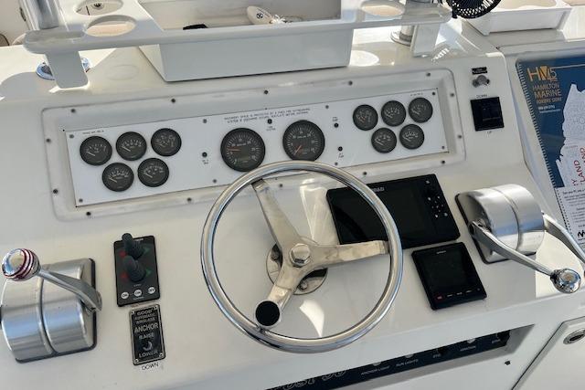 Control panel of a 1995 Post 50 Convertible boat with steering wheel and gauges.