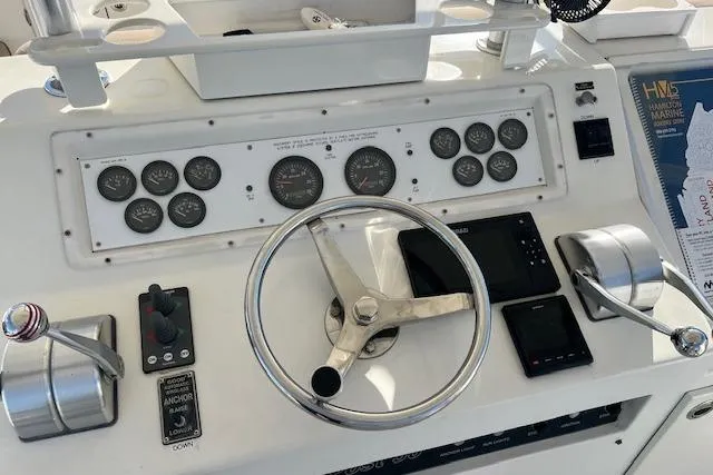 Control panel of a 1995 Post 50 Convertible boat with steering wheel and gauges.