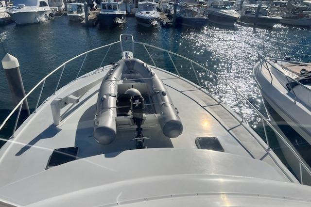 1995 Post 50 Convertible yacht with inflatable boat on deck, docked in a marina.