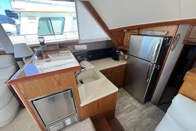 What's Next Yacht Photos Pics Interior of a 1995 Post 50 Convertible yacht kitchen with wood cabinetry and stainless steel appliances.