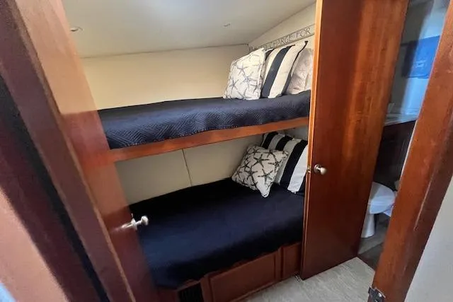 What's Next Yacht Photos Pics 1995 Post 50 Convertible yacht cabin with bunk beds and wooden interior.