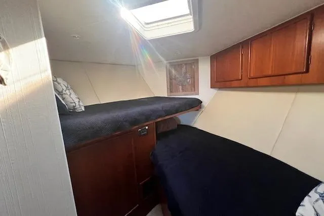 What's Next Yacht Photos Pics 1995 Post 50 Convertible cabin interior with twin beds and wooden cabinets.