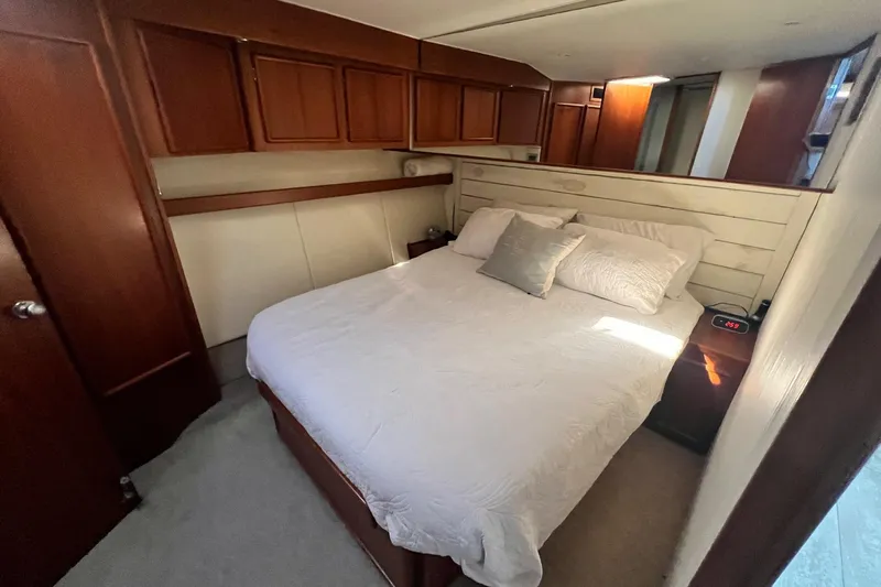 What's Next Yacht Photos Pics Luxurious bedroom interior of a 1995 Post 50 Convertible yacht with elegant wood finishes.