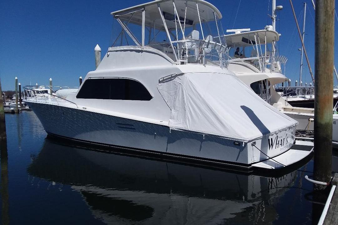 Luxury 1995 Post 50 Convertible yacht docked at marina under clear blue sky.