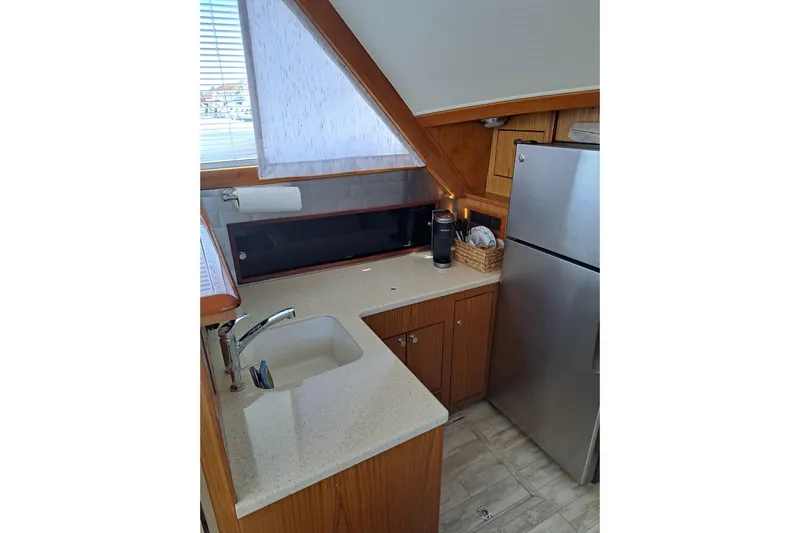 What's Next Yacht Photos Pics Compact kitchen in a 1995 Post 50 Convertible yacht with modern appliances and wood cabinetry.