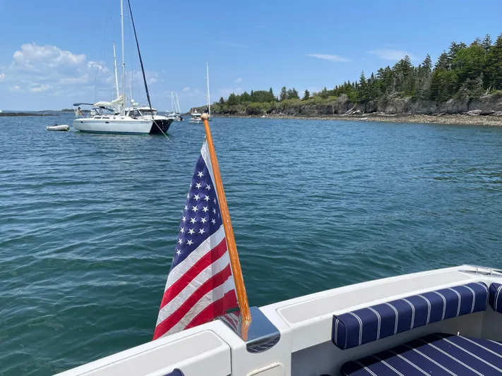 Halcyon Yacht Photos Pics American flag on a 2006 Back Cove 29 boat, scenic coastal view.