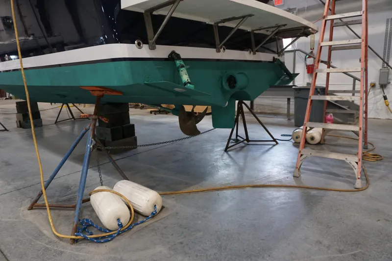 Halcyon Yacht Photos Pics 2006 Back Cove 29 boat in a workshop, supported by stands and a ladder.