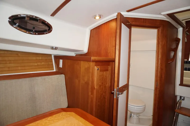 Halcyon Yacht Photos Pics Interior of 2006 Back Cove 29 boat, featuring wooden cabinetry and a compact bathroom.