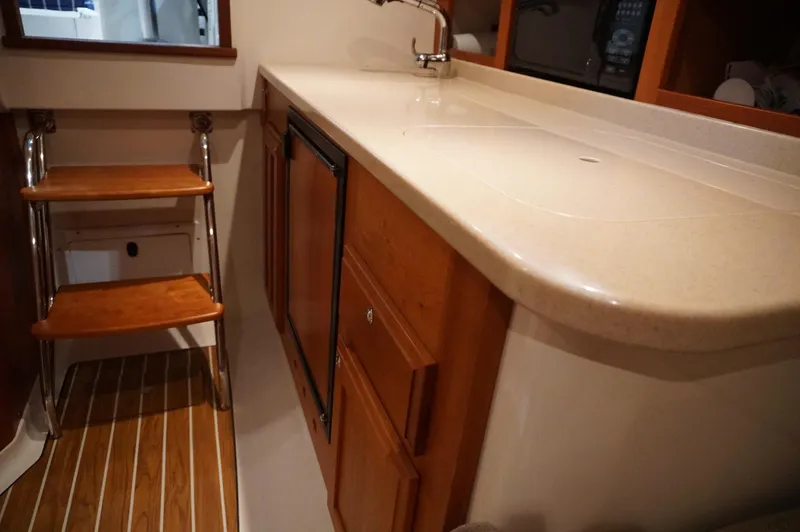Halcyon Yacht Photos Pics 2006 Back Cove 29 interior with wooden steps, countertop, and cabinetry.