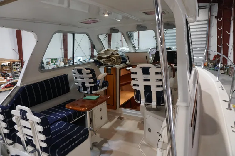 Halcyon Yacht Photos Pics Interior of 2006 Back Cove 29 boat with striped seating and wooden table.