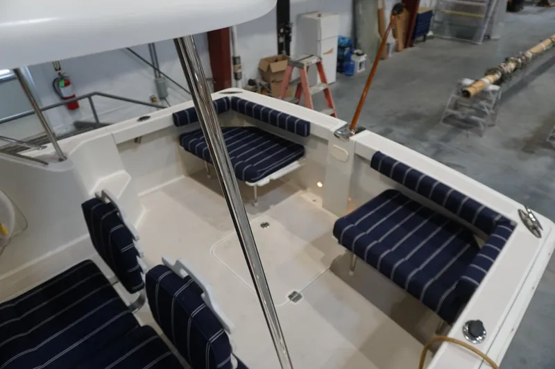 Halcyon Yacht Photos Pics 2006 Back Cove 29 boat interior with striped seating in a workshop setting.
