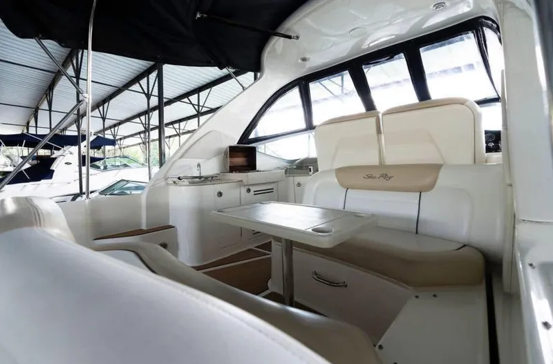  Yacht Photos Pics 2008 Sea Ray 310 Sundancer interior with seating and table in a covered marina.