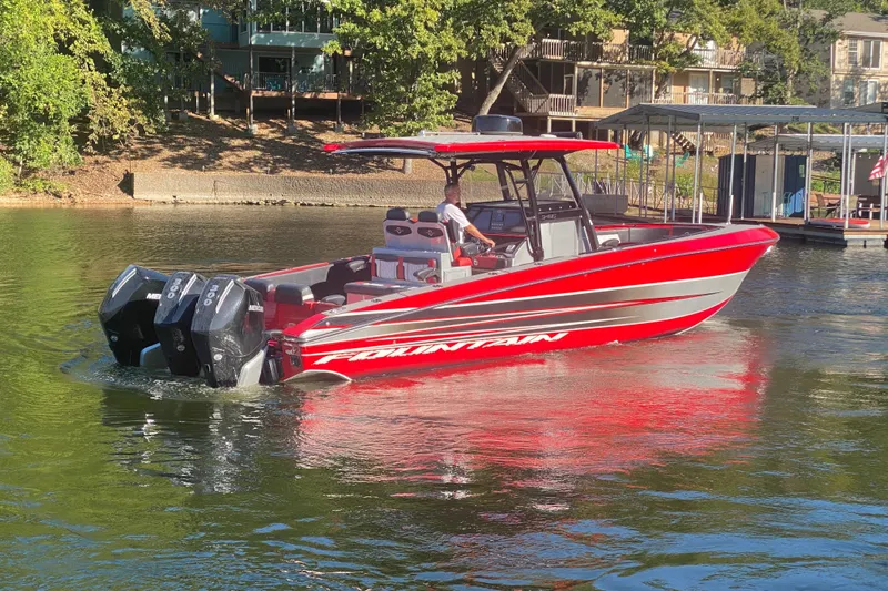  Yacht Photos Pics Red 2021 Fountain 34 SC boat cruising on a sunny lake near docks.