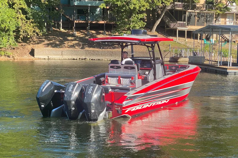  Yacht Photos Pics 2021 Fountain 34 SC boat with triple Mercury engines on a calm lake.