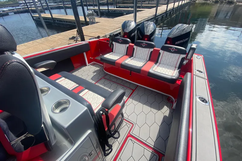  Yacht Photos Pics 2021 Fountain 34 SC boat interior with red and gray seating, docked by the water.