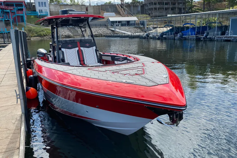  Yacht Photos Pics Red and white 2021 Fountain 34 SC boat docked on calm water.