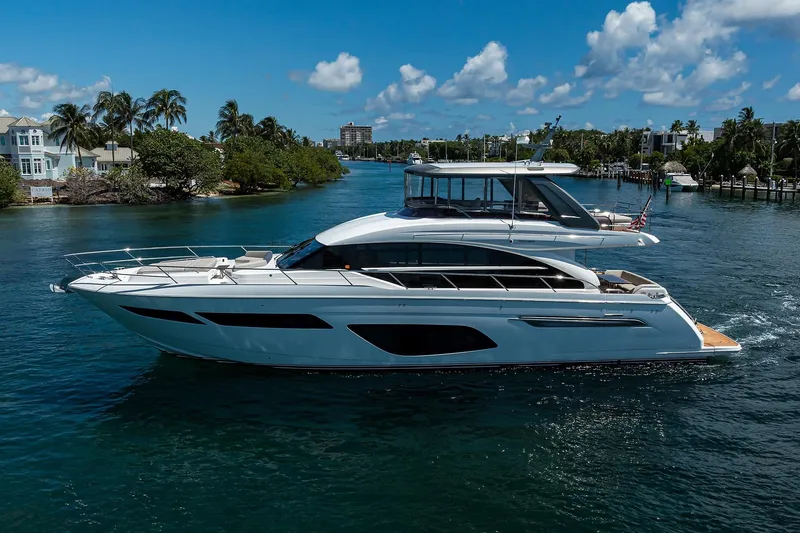 Miss Amy Yacht Photos Pics Luxurious 2020 Princess F70 yacht cruising on a scenic waterway under a clear blue sky.