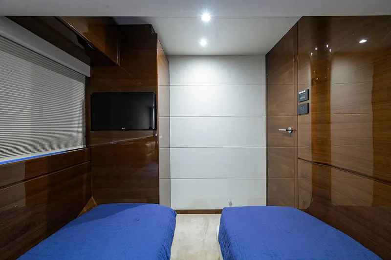 Miss Amy Yacht Photos Pics Luxurious 2020 Princess F70 yacht cabin with twin beds, TV, and sleek wood paneling.