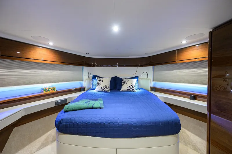Miss Amy Yacht Photos Pics Luxurious 2020 Princess F70 yacht bedroom with blue bedding and elegant wood finishes.