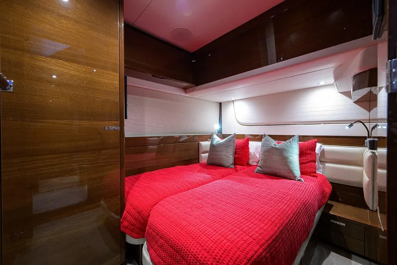 Miss Amy Yacht Photos Pics Luxurious cabin interior of 2020 Princess F70 yacht with red bedding and wood paneling.