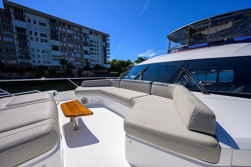 Miss Amy Yacht Photos Pics Luxurious 2020 Princess F70 yacht deck with seating and table, near waterfront buildings.