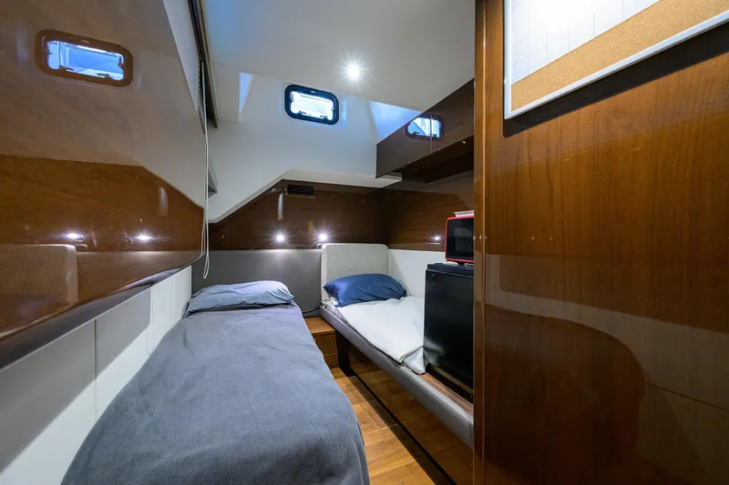 Miss Amy Yacht Photos Pics Luxurious cabin interior of 2020 Princess F70 yacht with wooden finishes and cozy bedding.