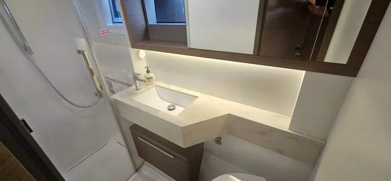  Yacht Photos Pics Modern bathroom in a 2022 Lagoon 50 yacht, featuring sleek sink and shower design.