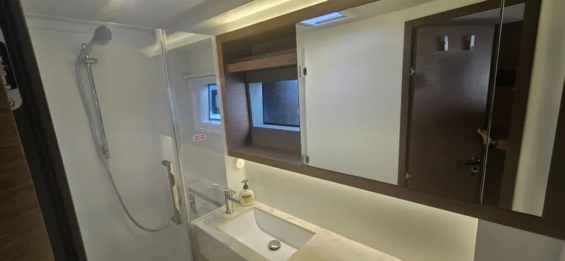 Yacht Photos Pics Modern bathroom in 2022 Lagoon 50 yacht with shower, sink, and mirror.