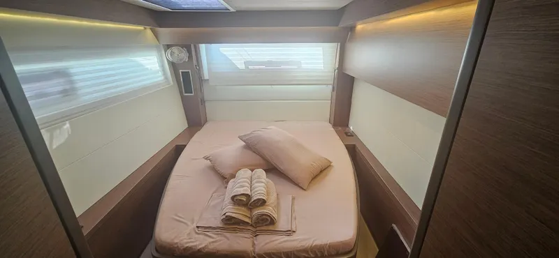  Yacht Photos Pics Luxurious cabin interior of 2022 Lagoon 50 yacht with cozy bedding and ambient lighting.