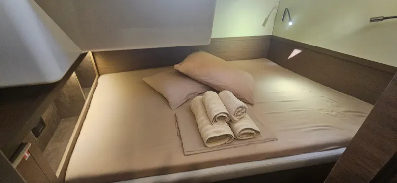  Yacht Photos Pics Luxurious cabin interior of 2022 Lagoon 50 yacht with neatly arranged bed and towels.