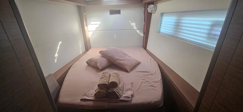  Yacht Photos Pics Cozy bedroom in 2022 Lagoon 50 yacht with neatly arranged bed and soft lighting.