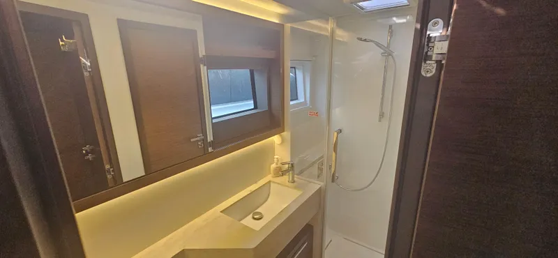  Yacht Photos Pics Luxurious bathroom in 2022 Lagoon 50 yacht with modern fixtures and elegant lighting.