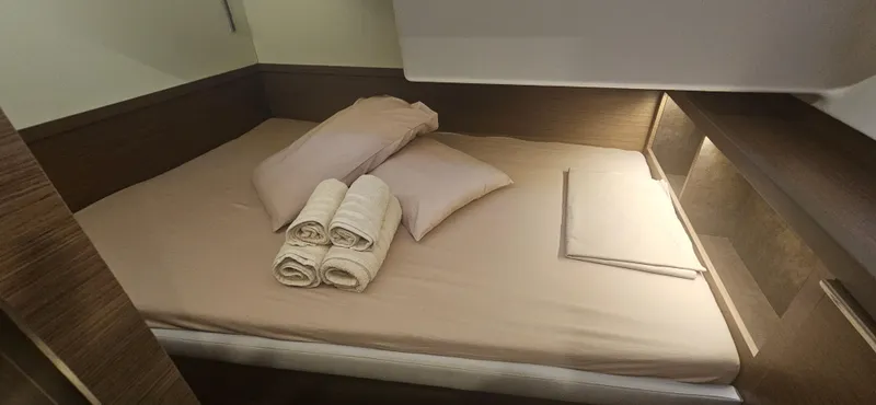  Yacht Photos Pics Luxurious cabin interior of 2022 Lagoon 50 yacht with neatly arranged bed and towels.