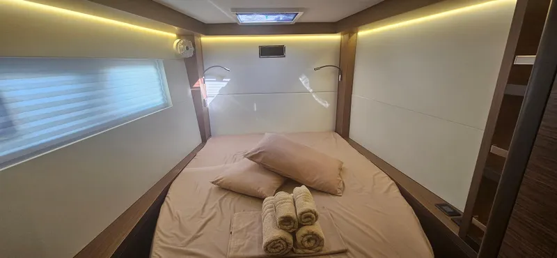  Yacht Photos Pics Luxurious cabin interior of 2022 Lagoon 50 yacht with cozy bedding and ambient lighting.