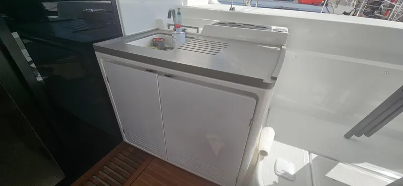  Yacht Photos Pics Outdoor kitchenette on 2022 Lagoon 50 yacht with sink and storage cabinets.