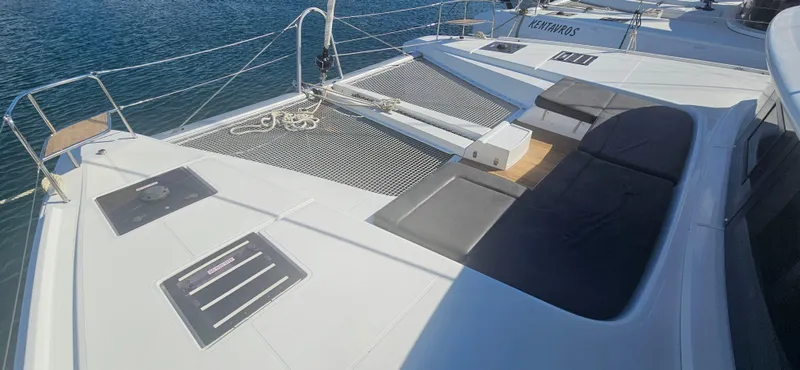  Yacht Photos Pics 2022 Lagoon 50 catamaran deck with netting and seating, on calm blue water.