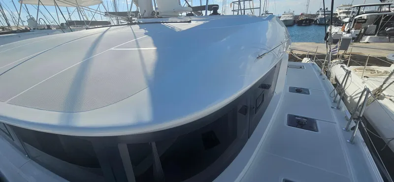  Yacht Photos Pics 2022 Lagoon 50 yacht docked at marina, showcasing sleek design and spacious deck.