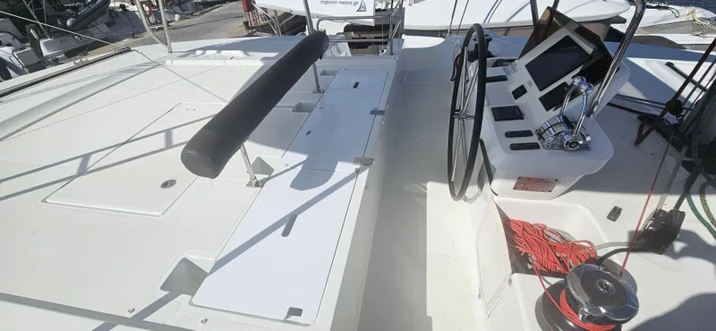  Yacht Photos Pics 2022 Lagoon 50 yacht deck with steering wheel and navigation equipment.