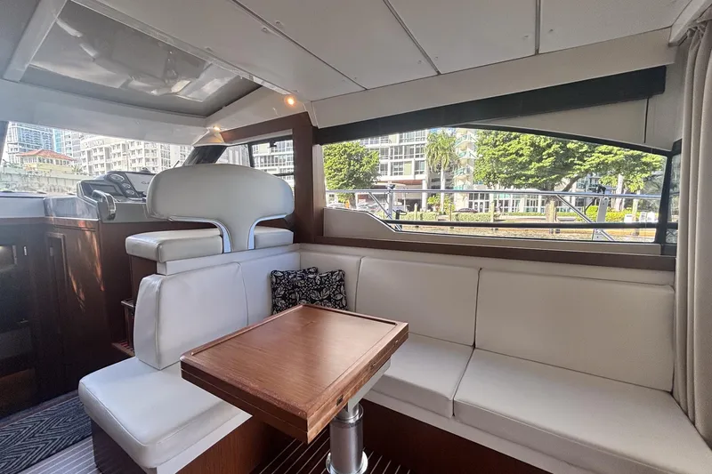 Fly-away Yacht Photos Pics Interior of 2015 Bavaria 420 Virtess Coupe with white seating and wooden table.